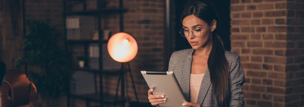 Professionista che utilizza un tablet in un ambiente lavorativo moderno, immagine dedicata al bando FRI-TUR Fondo Rotativo Imprese Turistiche per innovazione e digitalizzazione.
